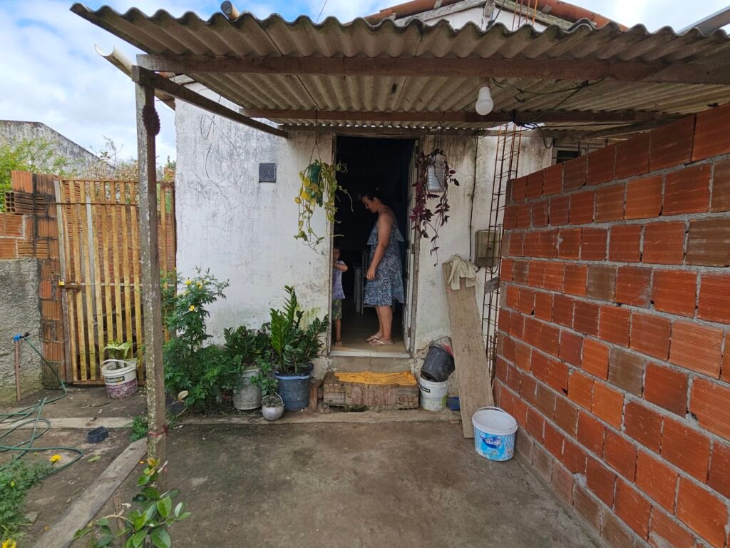 A woman standing in the doorway of her home in Queimadas, Brazil