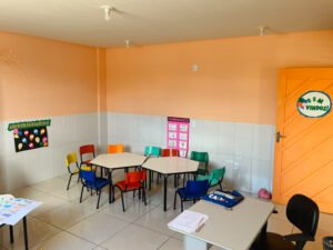 classroom with orange walls and colorful chairs and desks at the FAD community center