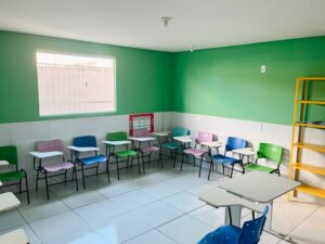 classroom with green walls and colorful chairs and desks at the FAD community center