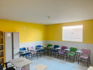 classroom with yellow walls and colorful chairs and desks at the FAD community center
