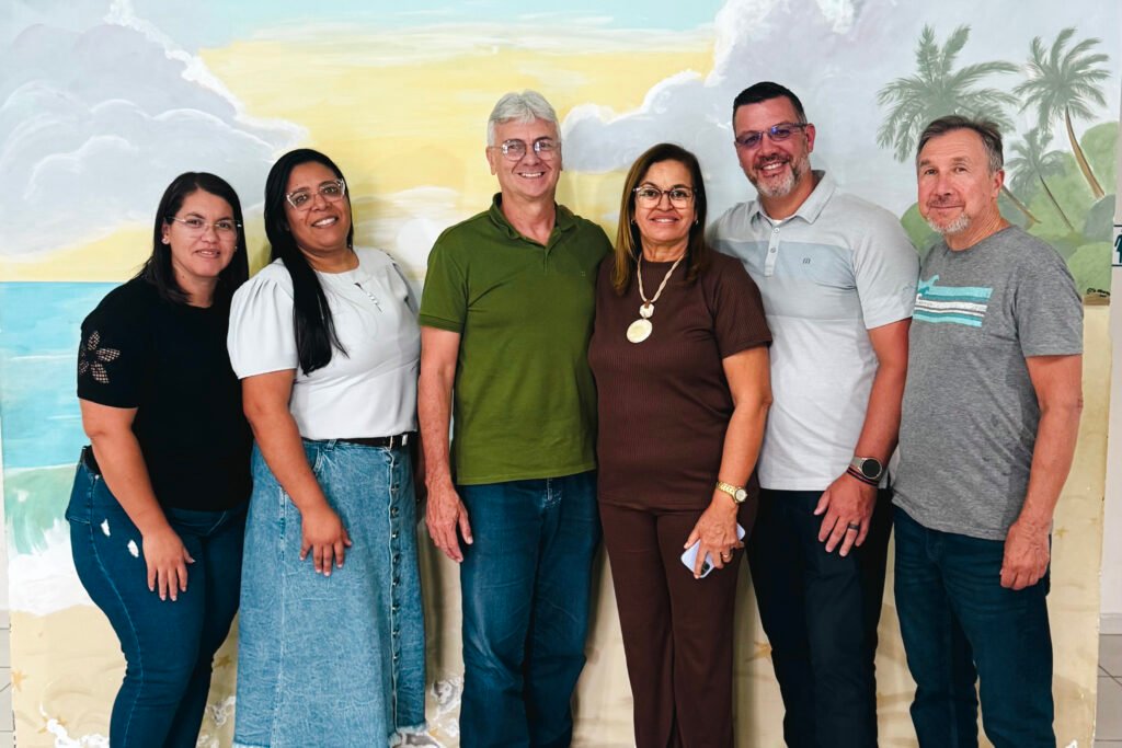 Six people standing in front of a wall with a mural at the FAD center, smiling