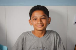 Young boy smiling at camera in a gray FAD tshirt