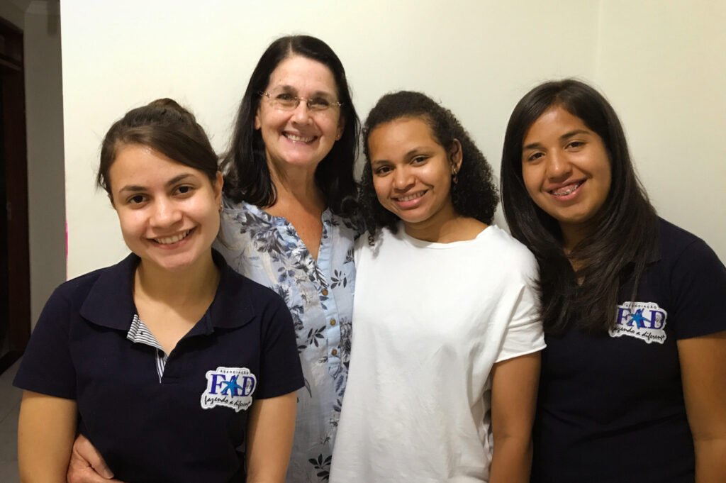 A woman posing with three young girls at the FAD center in Brazil