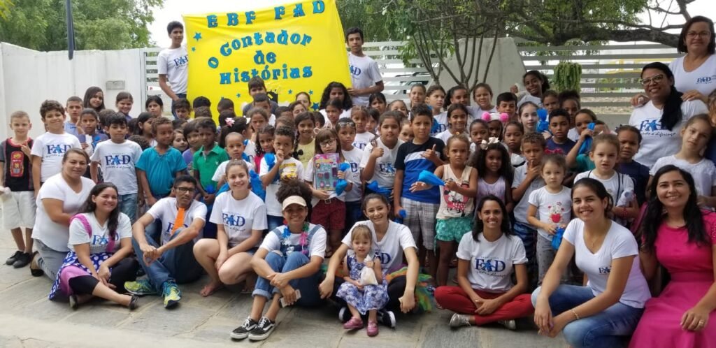 Mary Wagner posing with a large group of FAD staff and children outside
